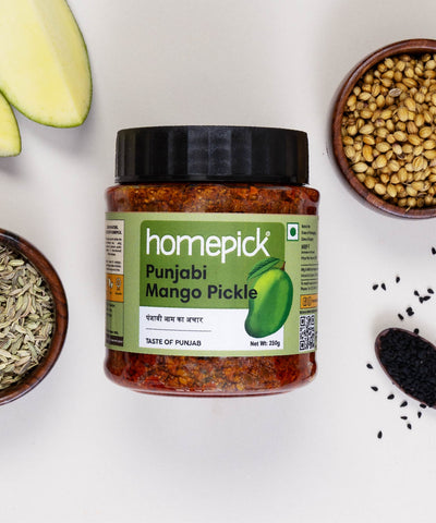 Jar of homepick Punjabi Mango Pickle with ingredients on a white background