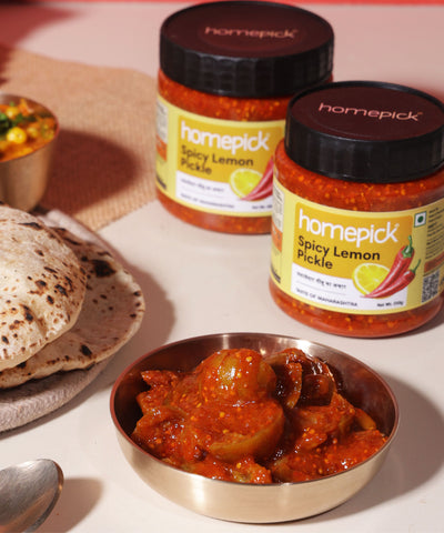 Homepick Spicy Lemon Pickle jars with a bowl of pickle and flatbread on a light background