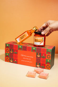 Hand reaching for a jar of pickles on a festive gift box 